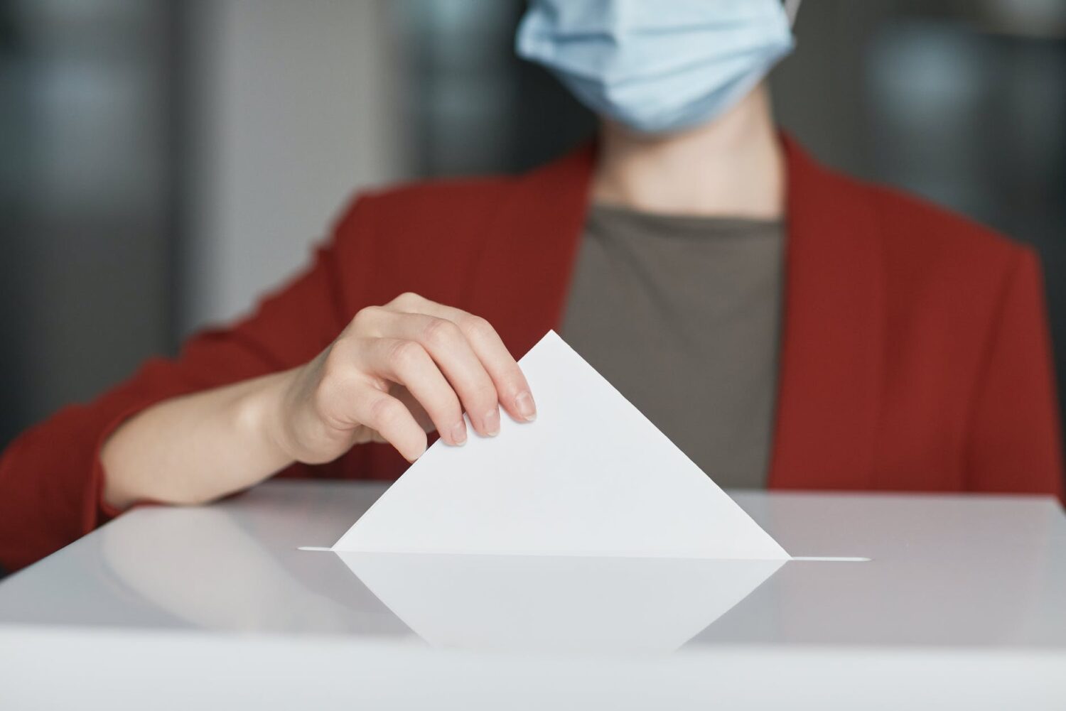 ballot box with person casting a vote