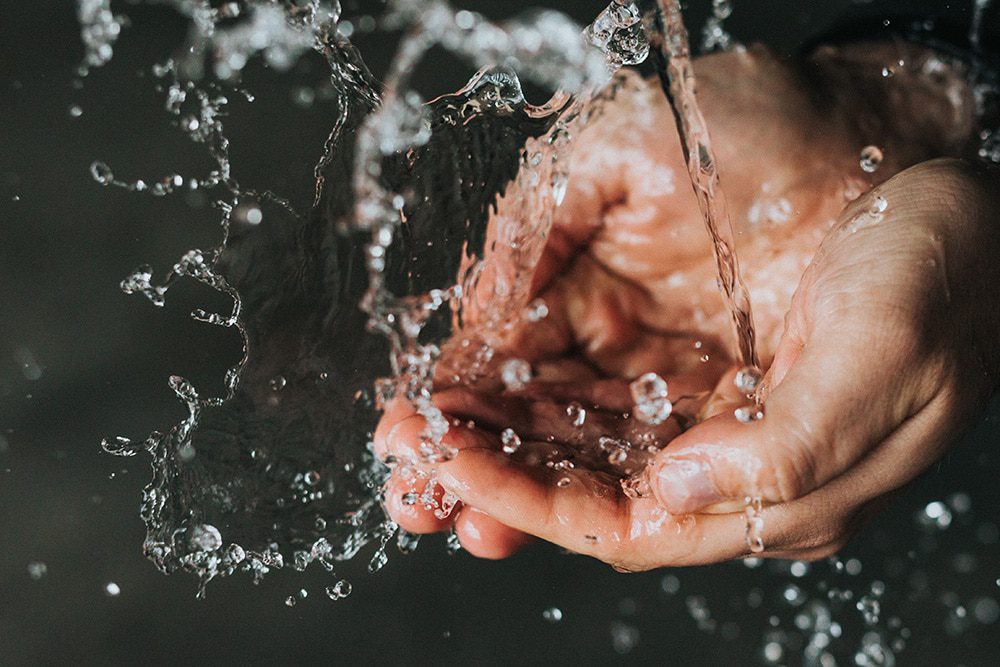 water flows over two joined hands - World Hand Hygiene Day