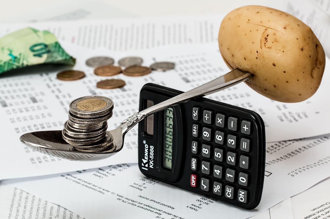 inflation - spoon holding coins and a potato, trying to balance