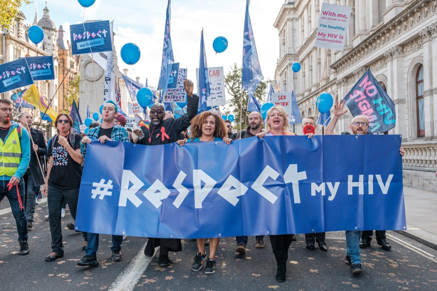 a group of people marching down a street holding a sign