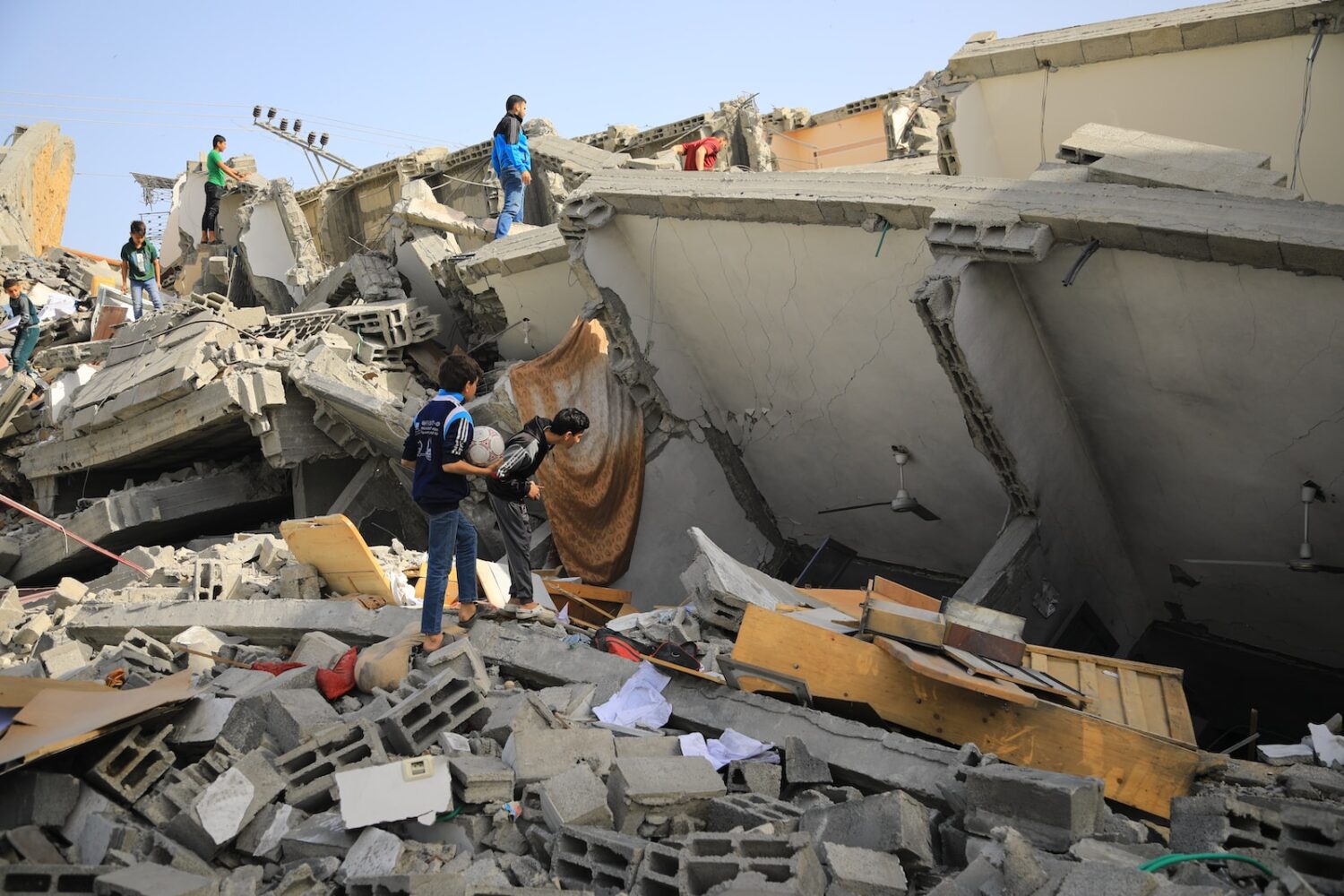 a group of people standing next to a collapsed building