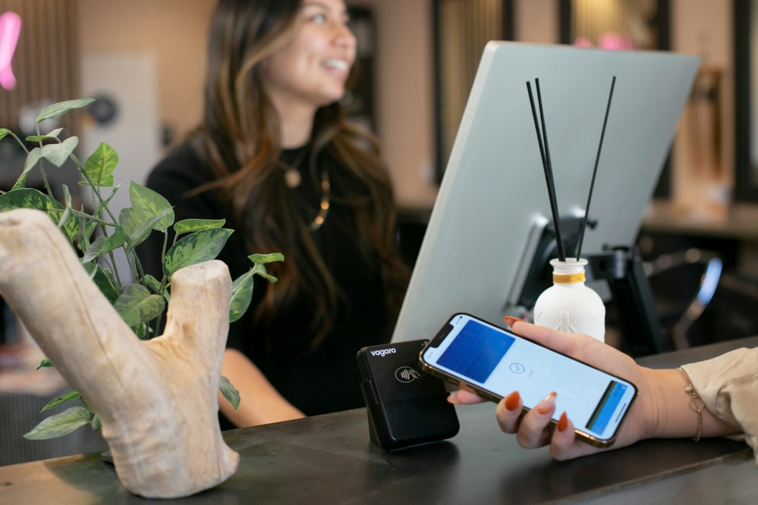 a woman sitting at a desk using a cell phone